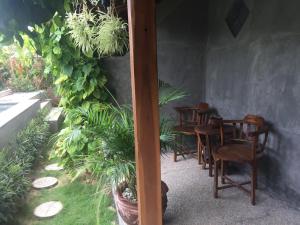 een groep stoelen en tafels in een kamer met planten bij Watukarung Ristu Homestay in Kalak