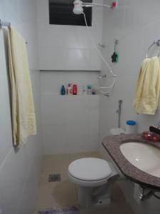 a bathroom with a toilet and a sink at Condomínio Caribe Fortaleza CE in Caucaia