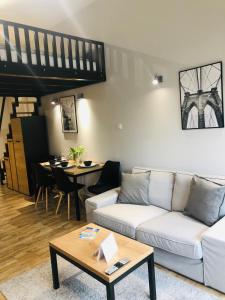 - un salon avec un canapé blanc et une table dans l'établissement Property Apart - Soft Lofty Legnicka Centrum, à Wrocław