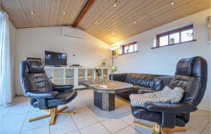 a living room with leather furniture and a table at 2 Bedroom Cozy Home In Eg in Skæring
