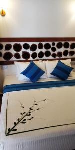 a bedroom with a bed with blue and white pillows at Alkina lodge in Fulidhoo