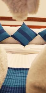 a bed with blue and white pillows on it at Alkina lodge in Fulidhoo