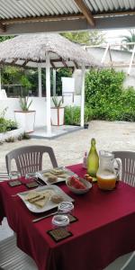 uma mesa com uma toalha de mesa vermelha com comida em Alkina lodge em Fulidhoo
