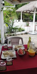 uma mesa com um prato de comida numa toalha de mesa vermelha em Alkina lodge em Fulidhoo