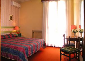 a bedroom with a bed and a large window at Hotel La Meridiana in Brisighella