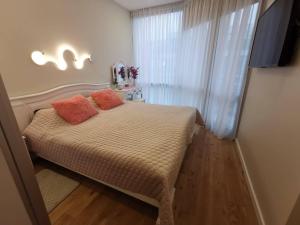 a bedroom with a bed with two pillows on it at Snieguolės apartamentai in Palanga