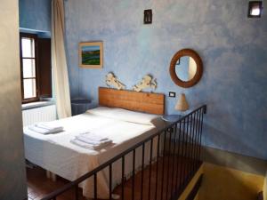 a bedroom with a bed with a mirror on the wall at Borgo Santa Maria in Monteleone dʼOrvieto