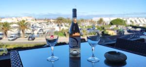 a bottle of wine sitting on a table with two wine glasses at L'After Port Nature in Cap d'Agde