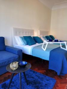 a bedroom with a large bed and a blue couch at Blue Bairro Guesthouse in Lisbon