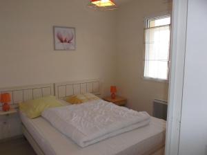 a bedroom with a white bed with a pink flower on the wall at villa marine 2 in Jullouville-les-Pins