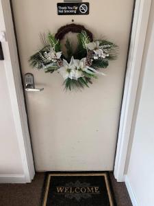 a wreath on a door with a welcome mat at Gatlinburg Mountain Condo in Gatlinburg