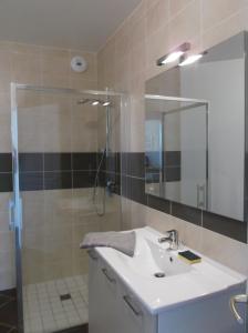 a bathroom with a sink and a shower with a mirror at villa marine 2 in Jullouville-les-Pins