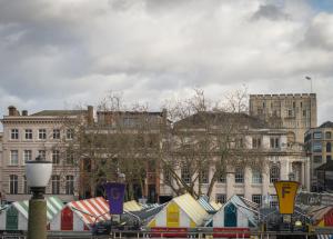 um grupo de tendas coloridas em frente aos edifícios em The Old Post Office Court em Norwich