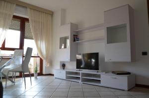 uma sala de estar com uma televisão de ecrã plano e uma mesa em Giusy Monreale Apartment em Cagliari