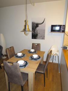 a dining room table with chairs and a cow picture on the wall at Ferienwohnung Seepferdchen in Timmendorfer Strand