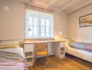 een slaapkamer met een bureau, een bed en een raam bij Villa-Holzreich in Lohme