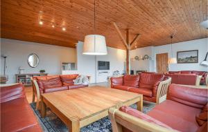 a living room with a wooden ceiling and a table at Lystrup Gamle Skole in Nørager