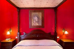 um quarto com uma parede vermelha com uma cama e uma fotografia em Suite D'Autore Art Design Gallery em Piazza Armerina