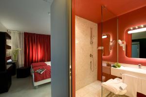 baño con paredes rojas y baño con ducha. en San Ranieri Hotel, en Pisa