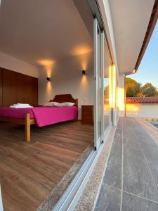 sypialnia z łóżkiem i dużym oknem w obiekcie Gondoriz-House w mieście Terras de Bouro