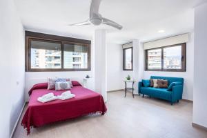 sypialnia z łóżkiem i niebieską kanapą w obiekcie LEVANTE BEACH FRONT OF THE SEA Estacha w mieście Benidorm +32 zdjęcia