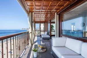 salon z kanapą na balkonie z widokiem na plażę w obiekcie LEVANTE BEACH FRONT OF THE SEA Estacha w mieście Benidorm