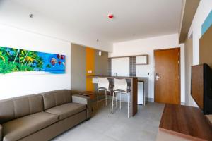 a living room with a couch and a kitchen at Apartamento em Resort de Olimpia in Olímpia