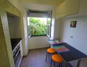 a kitchen with a table and two chairs and a window at Tram House @ Lx Factory! in Lisbon