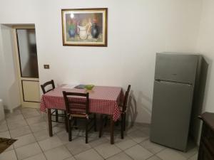 eine Küche mit einem Tisch und einem Kühlschrank in der Unterkunft CASA SERENA UNO - CENTRO STORICO in Montepulciano