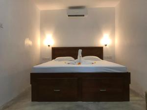 een slaapkamer met een bed met twee lampjes aan de muur bij The Loft in Midigama East