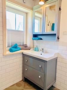 ein Bad mit einem Waschbecken und einem Spiegel in der Unterkunft Sunny Corner Holiday Apartment in Rheinböllen