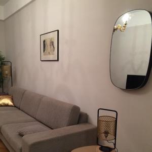 a living room with a couch and a mirror at MAGNIFIQUE APPARTEMENT JEAN MEDECIN/NOTRE DAME in Nice