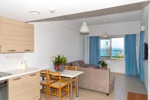 una cucina e un soggiorno con un divano e un tavolo di Helios Bay Hotel and Suites a Paphos