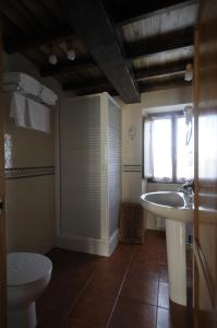 baño con lavabo y aseo y ventana en Apartamentos Rurales Romallande, en Puerto de Vega