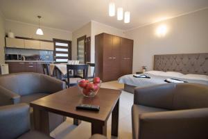 a hotel room with a bed and a table with a bowl of fruit on at Villa BALTICA in Rowy