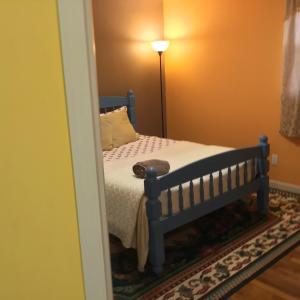 um quarto com uma cama, um candeeiro e um espelho em Beautiful Room near JFK and close to LaGuardia Airports em Laurelton