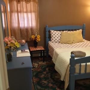 a bedroom with a blue bed and a table with flowers at Beautiful Room near JFK and close to LaGuardia Airports in Laurelton