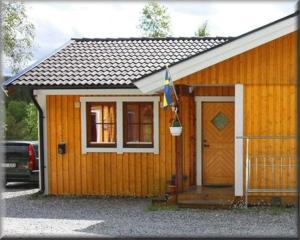 菲奈斯达伦Funäsdalens Stugby的一座带门和旗子的小木房子