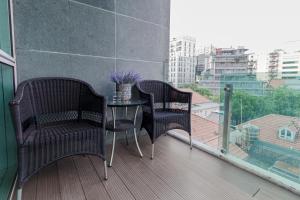 a balcony with two chairs and a table on a balcony at Blue Arch - Luxury Serviced Apartment in Central Saigon in Ho Chi Minh City