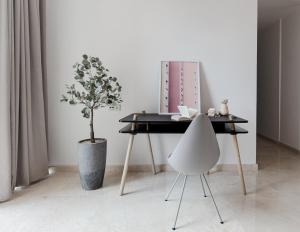 a table and a chair in a room with a plant at Blue Arch - Luxury Serviced Apartment in Central Saigon in Ho Chi Minh City