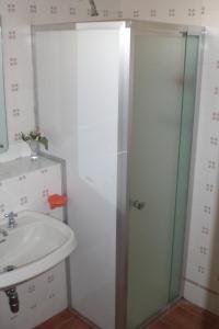 a bathroom with a glass shower door next to a sink at Hotel La Meridiana in Brisighella