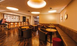 ein Restaurant mit Tischen und Stühlen und einer Bar in der Unterkunft Hotel Susato in Soest