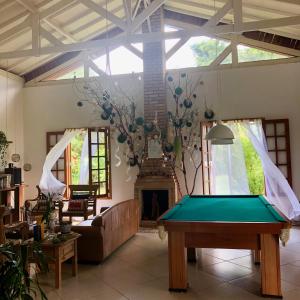 a living room with a pool table and a fireplace at Brotas Lodge in Brotas