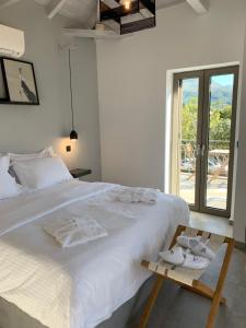 a bedroom with a large white bed with towels on it at Calme Suites Mani in Agios Nikolaos