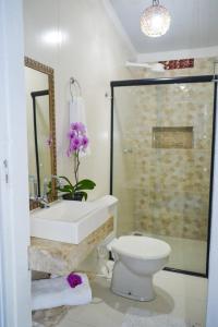 a bathroom with a sink and a toilet and a shower at Pousada Jambo in Trancoso