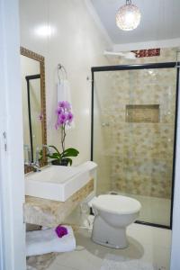 Un baño con lavabo, inodoro y ducha. en Pousada Jambo, en Trancoso 36 fotos más