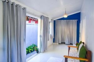 a living room with blue walls and curtains at Pousada Jambo in Trancoso