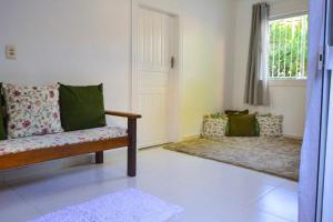 Una sala de estar con un sofá y una ventana. en Pousada Jambo, en Trancoso