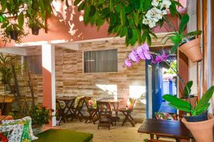 Habitación con mesa, sillas y plantas. en Pousada Jambo, en Trancoso