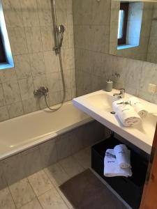 uma casa de banho com um lavatório, uma banheira e um chuveiro em Appartement Scherrhof em Kirchberg in Tirol